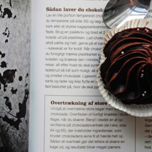 A chocolate cupcake on a cookbook